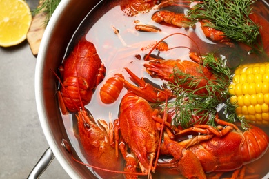 Fresh delicious crayfishes in pot on grey table, top view