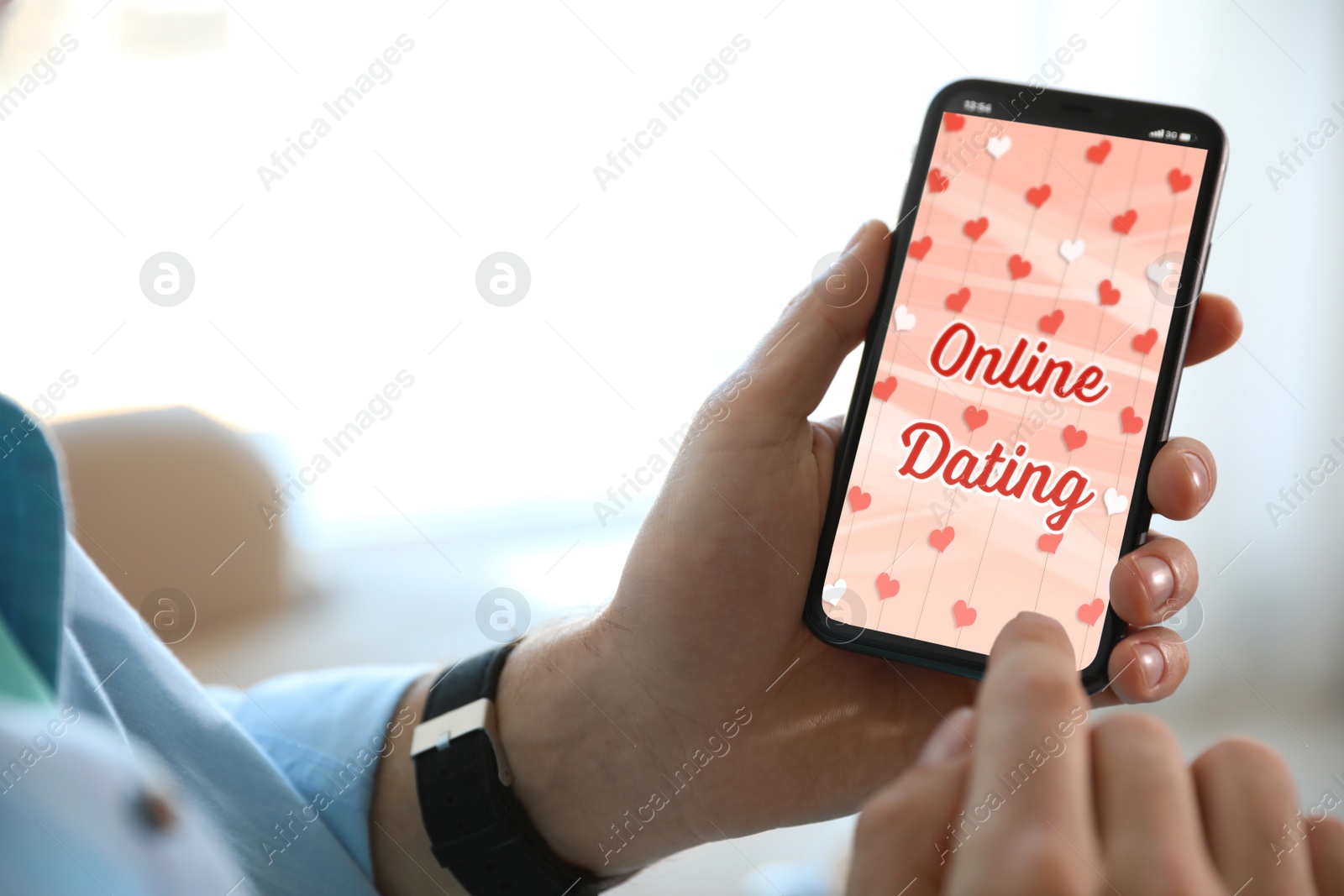 Image of Man visiting dating site via smartphone indoors, closeup