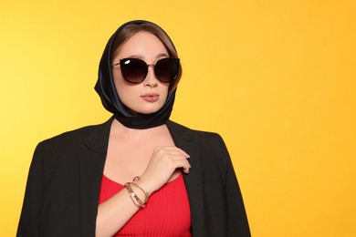 Photo of Young woman with lip piercing and sunglasses on yellow background. Space for text