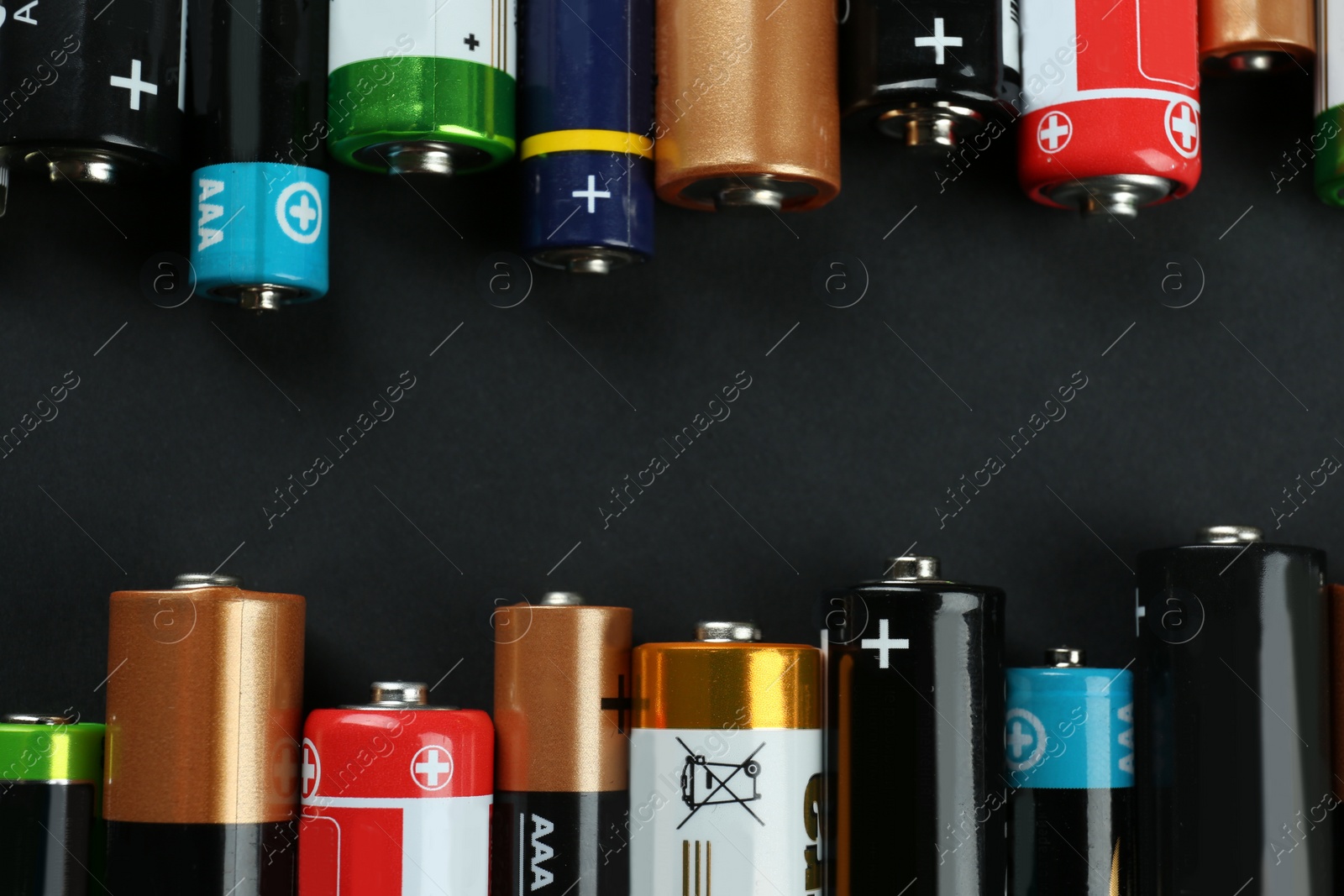 Image of Many different batteries on black background, flat lay