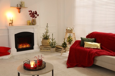 Living room with fireplace and Christmas decorations. Festive interior design