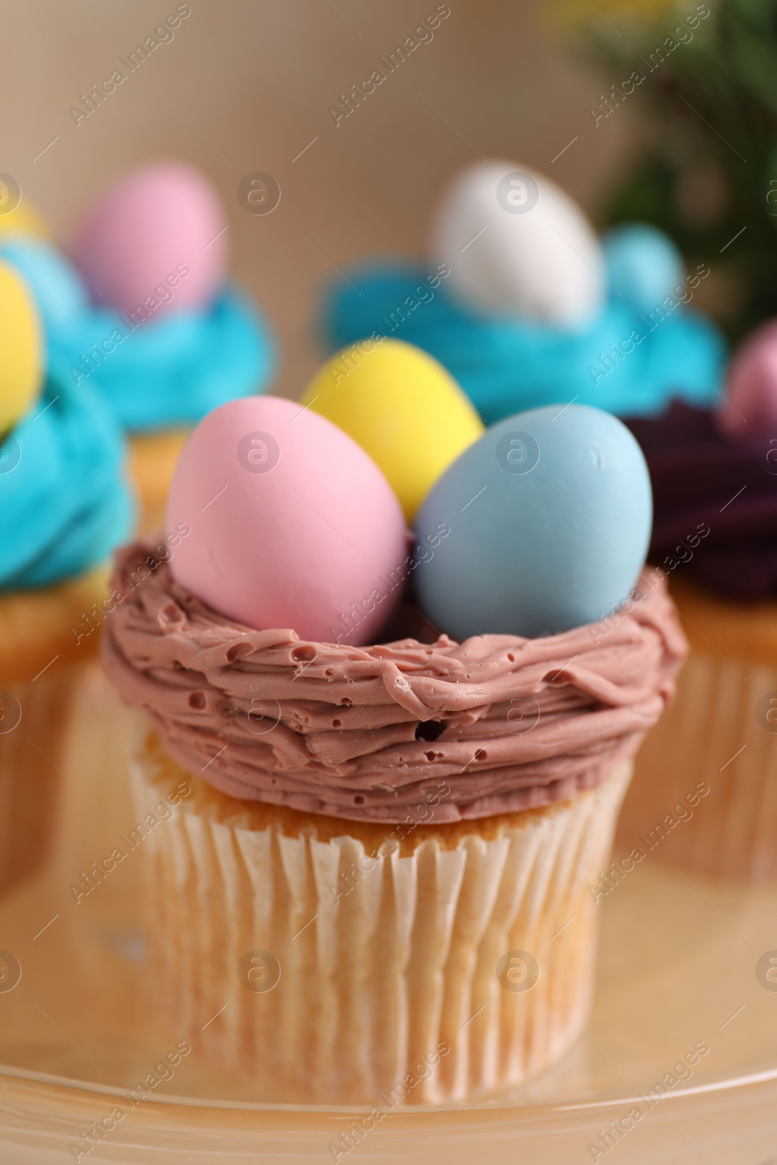 Photo of Tasty decorated Easter cupcakes on stand, closeup