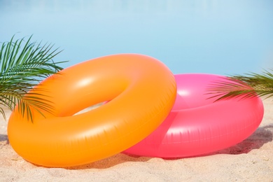 Photo of Colorful inflatable rings on sand. Beach object