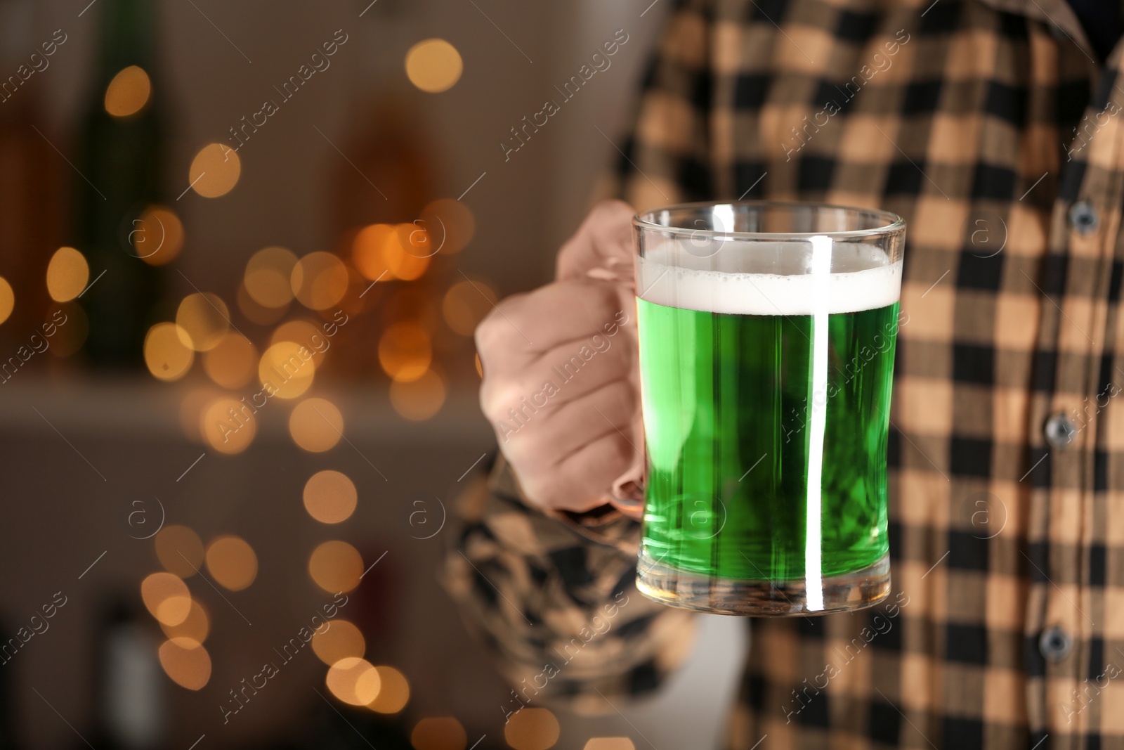 Photo of Closeup view of man with green beer in pub, space for text. St.Patrick's Day celebration