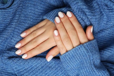 Woman showing her manicured hands with white nail polish, top view