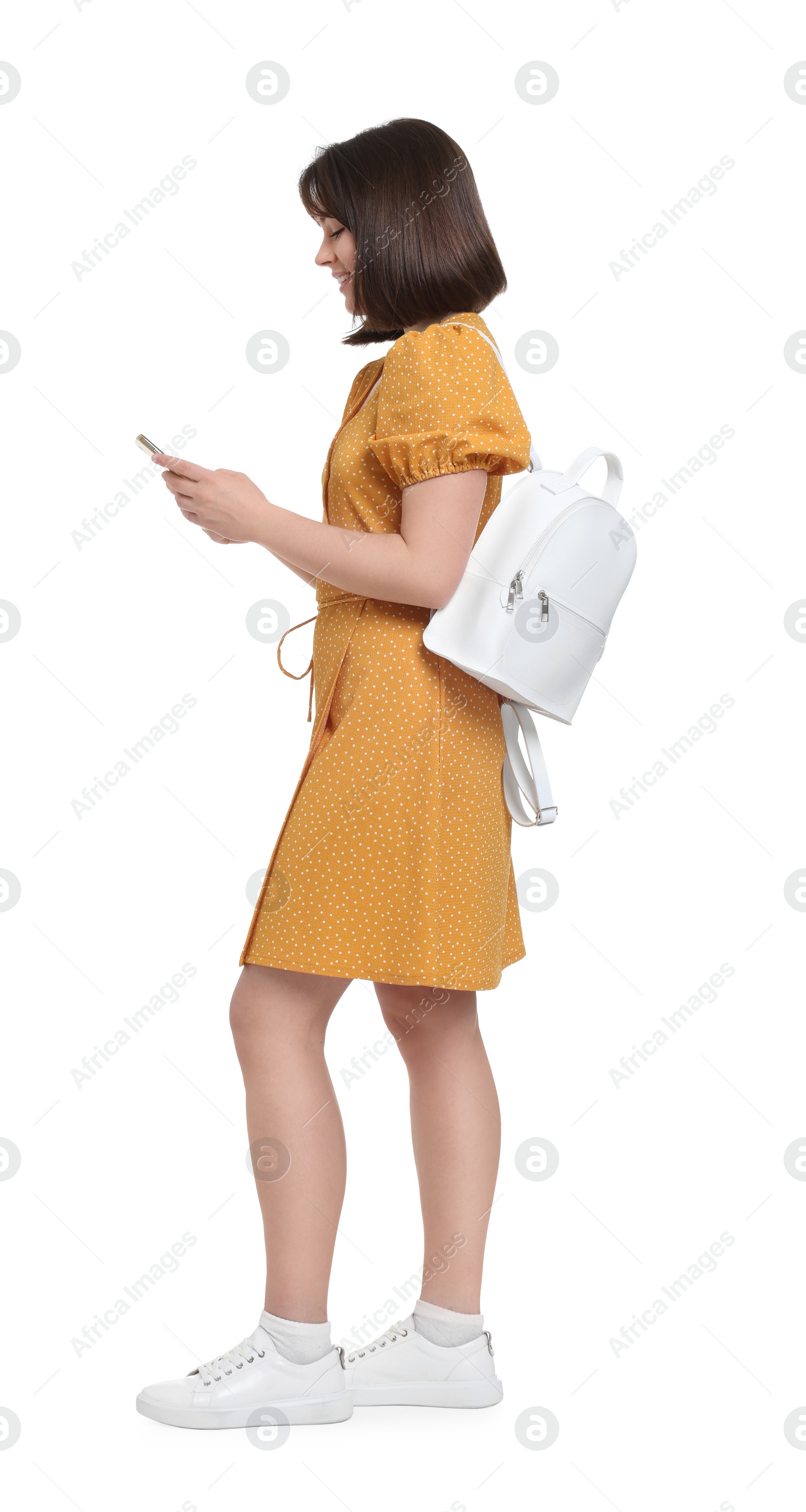 Photo of Happy woman with backpack using smartphone on white background