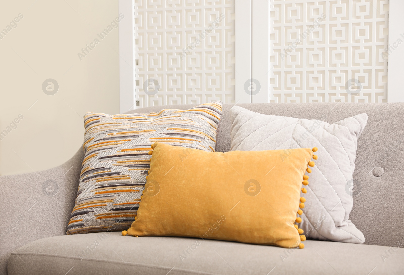 Photo of Comfortable sofa with different pillows in living room