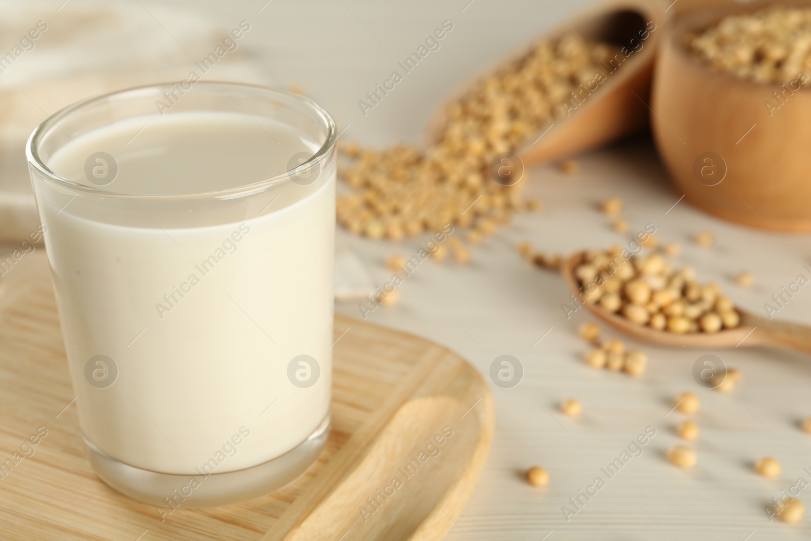 Photo of Fresh soy milk and beans on table, closeup. Space for text