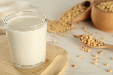 Photo of Fresh soy milk and beans on table, closeup. Space for text