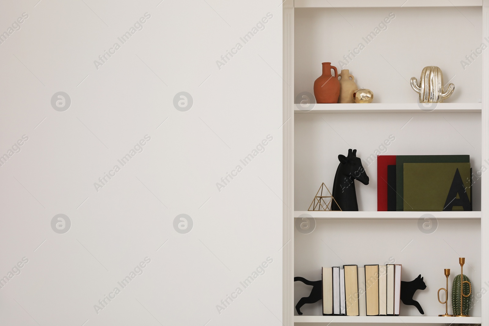 Photo of Stylish shelves with different decor elements indoors, space for text. Interior design