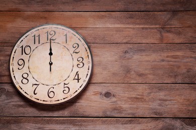 Photo of Stylish round clock on wooden table, top view with space for text. Interior element