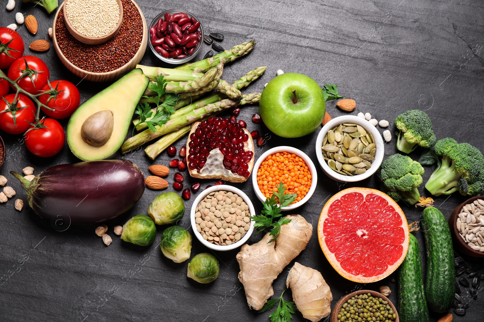 Photo of Fresh vegetables, fruits and seeds on black table, flat lay