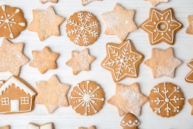 Photo of Tasty decorated Christmas cookies on wooden table, top view
