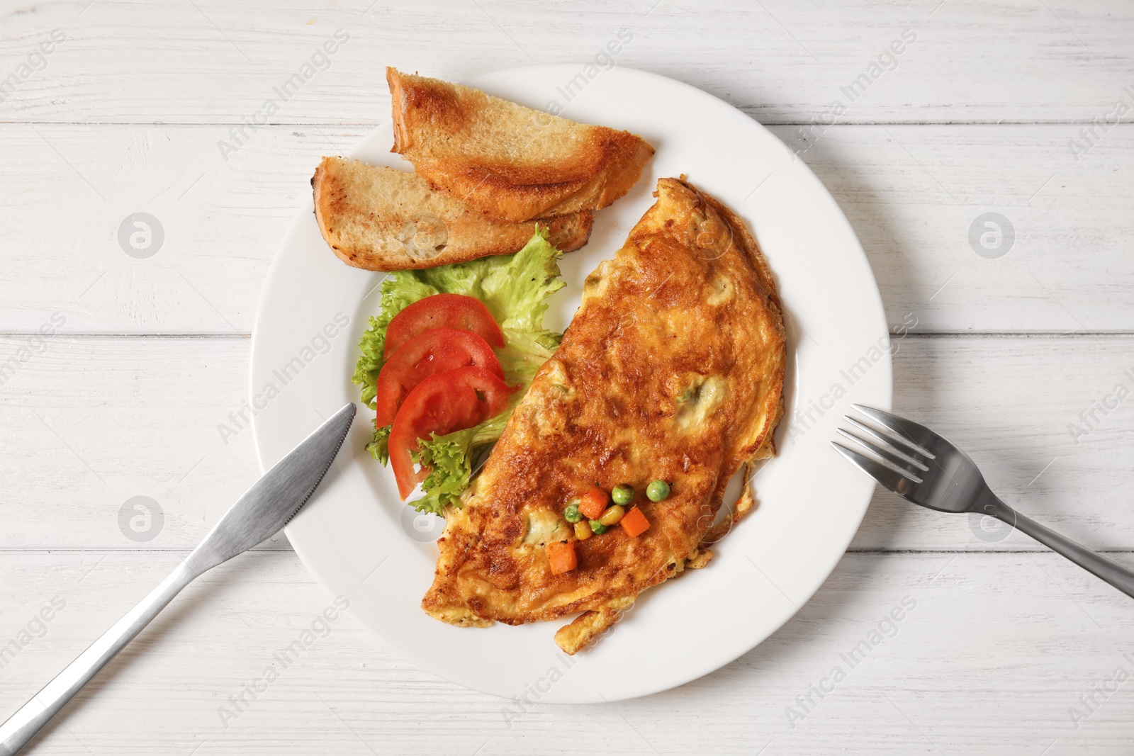 Photo of Omelet with vegetables on plate served for breakfast, top view