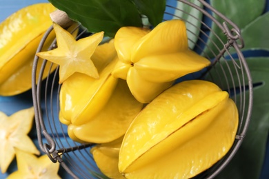 Delicious carambola fruits on blue table, top view