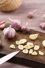 Photo of Fresh garlic and knife on table, closeup