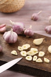 Fresh garlic and knife on table, closeup