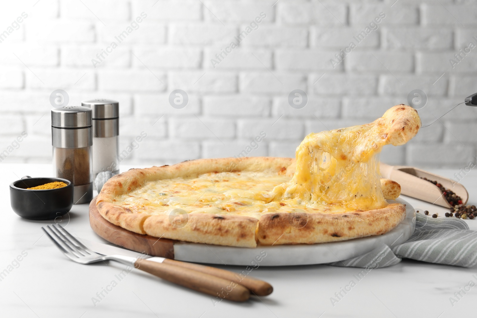 Photo of Taking piece of delicious cheese pizza at white table