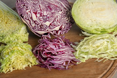 Different sorts of cabbage on wooden board, closeup