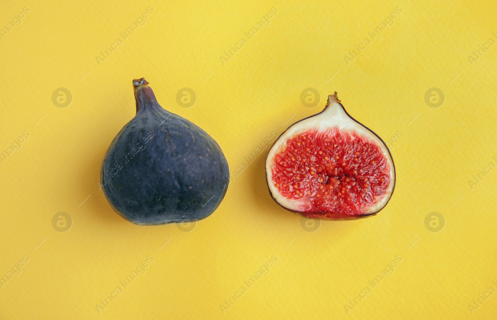 Photo of Delicious ripe figs on yellow background, flat lay