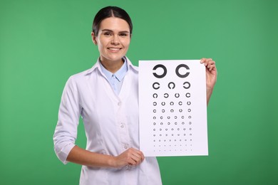 Ophthalmologist with vision test chart on green background