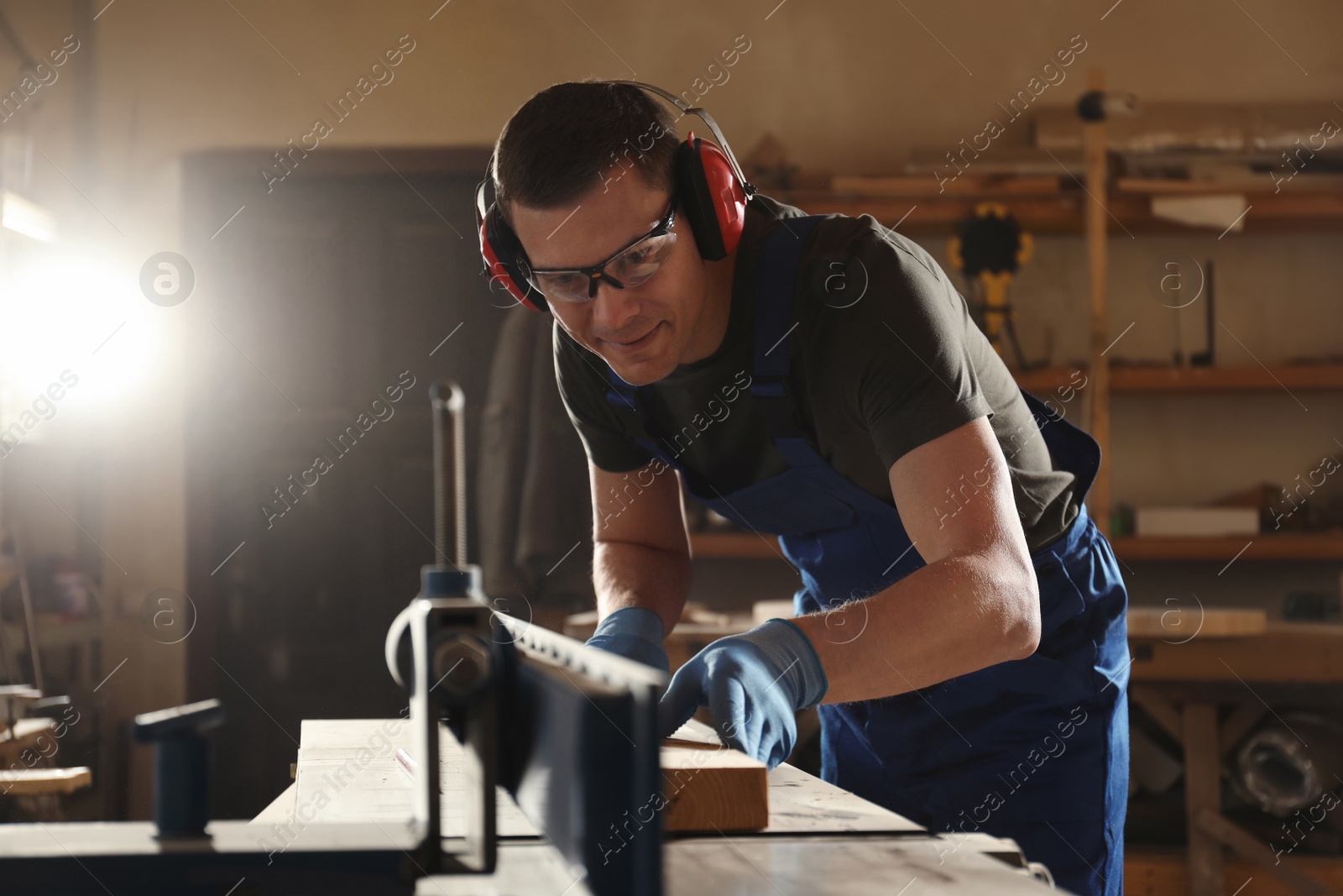 Photo of Professional carpenter working with wood in shop