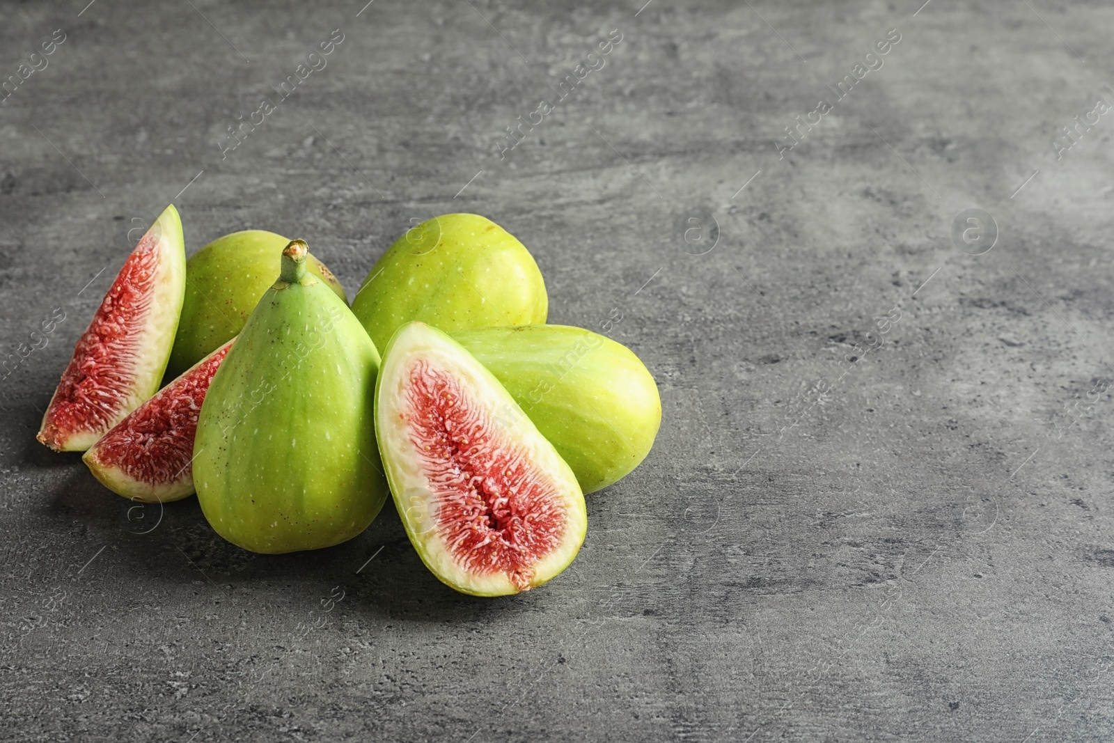 Photo of Fresh ripe figs on gray background. Space for text