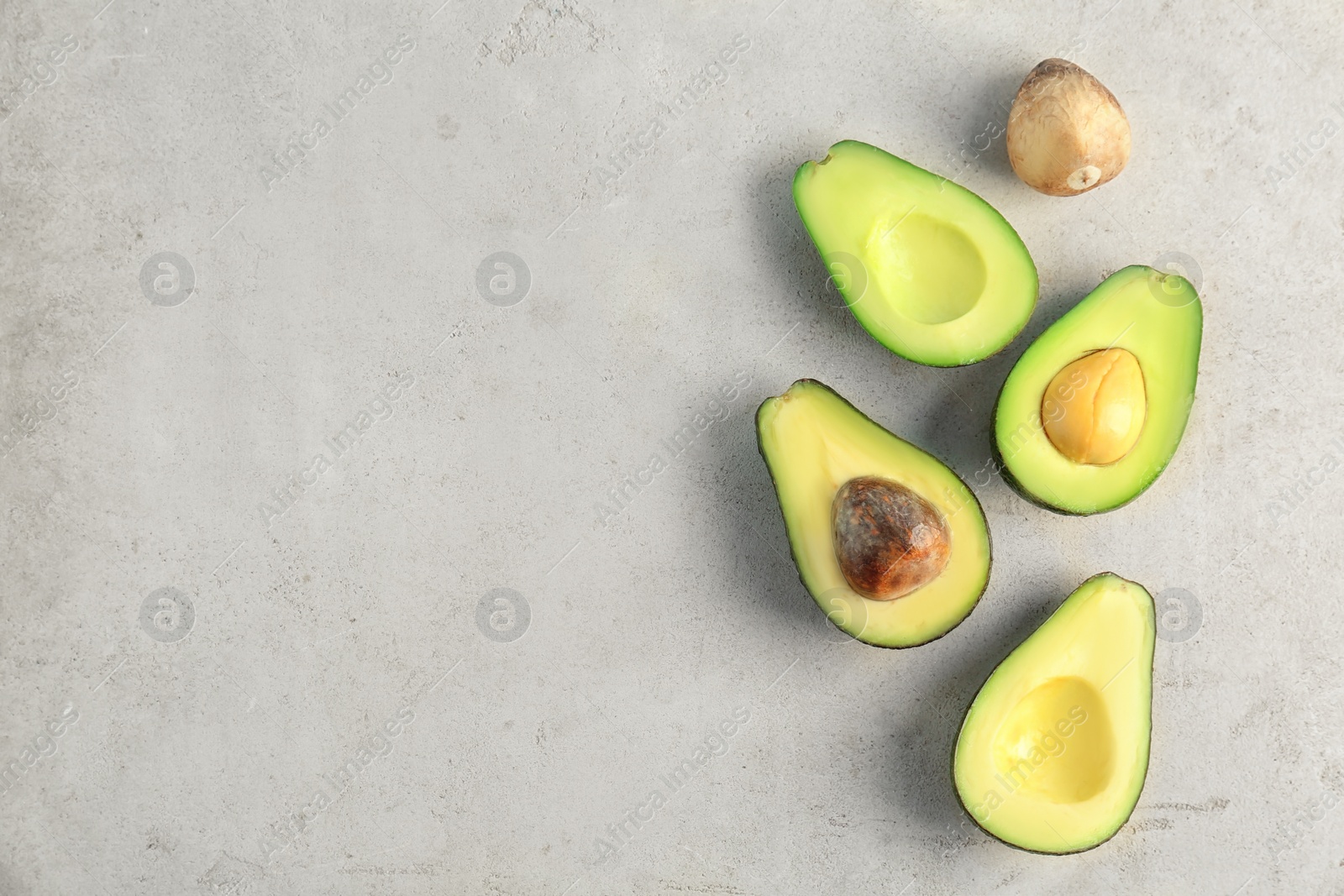 Photo of Flat lay composition with cut avocados on light background