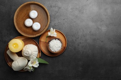 Flat lay composition with different spa products and lily flowers on grey table. Space for text