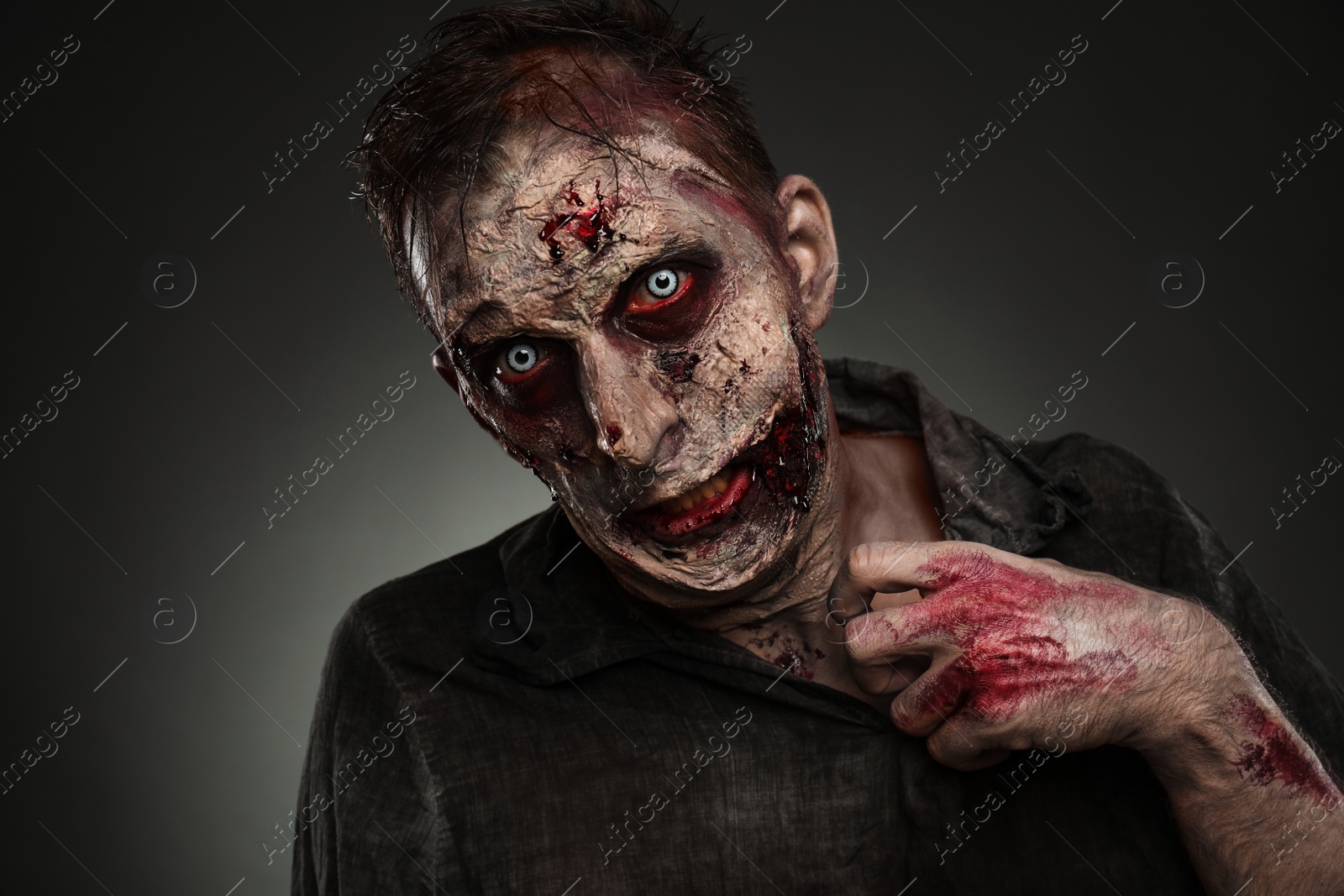 Photo of Scary zombie on dark background. Halloween monster