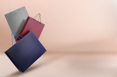 Image of Hot sale. Colorful shopping bags in air on pink beige gradient background, space for text