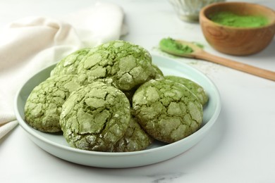 Plate with tasty matcha cookies on white table, closeup