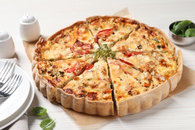 Photo of Tasty quiche with tomatoes and cheese served on white wooden table