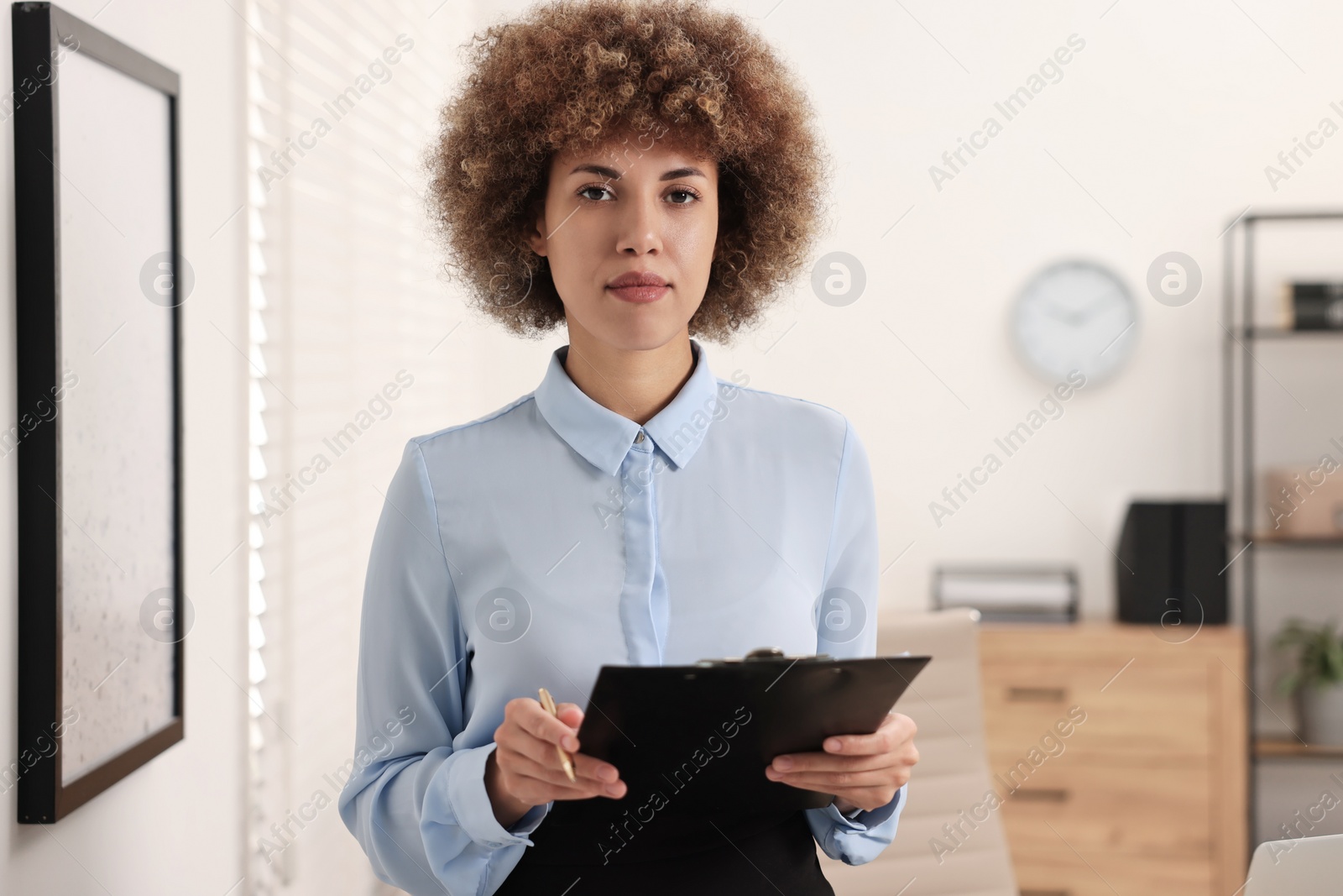 Photo of Notary with clipboard and pen in office