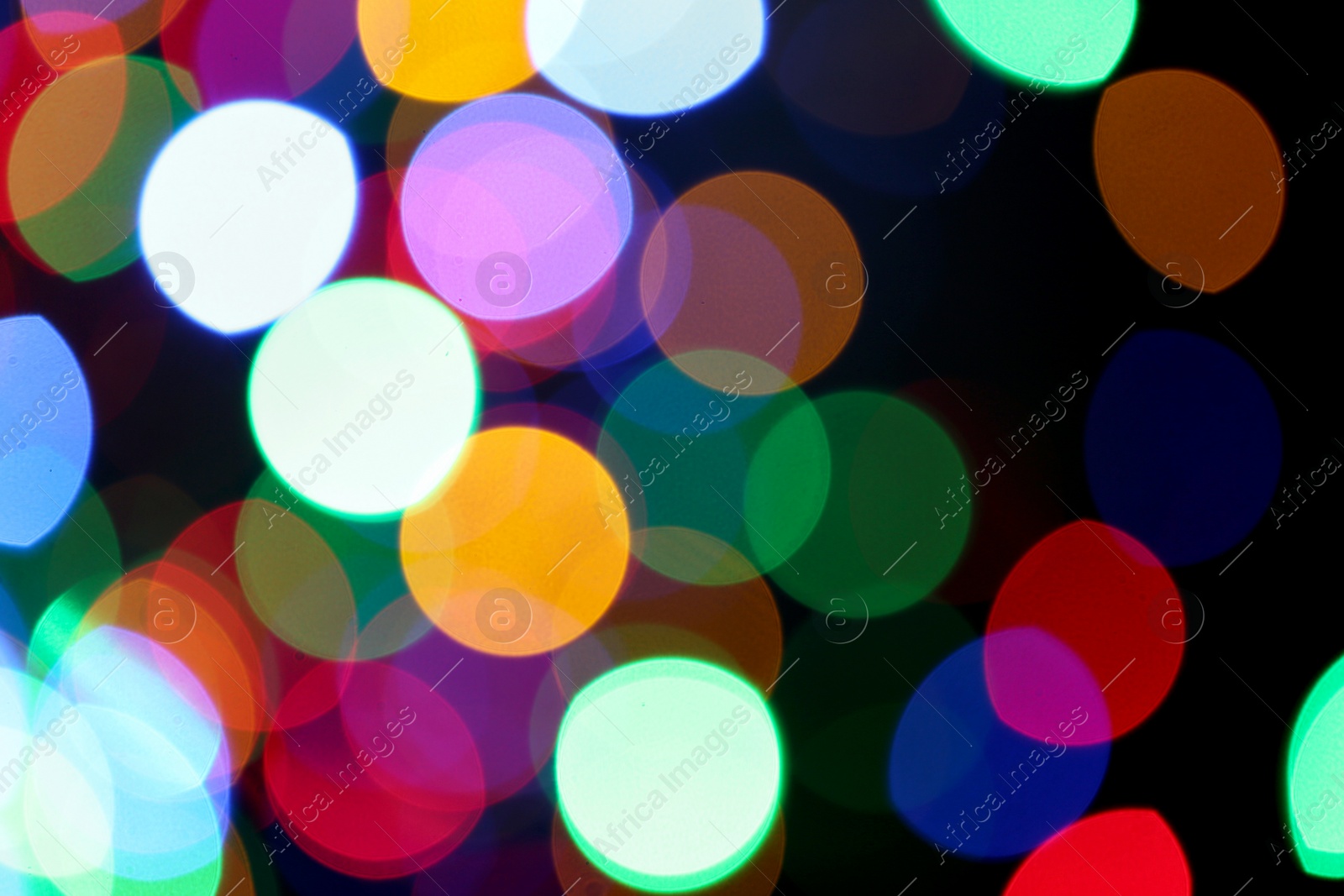 Photo of Blurred view of colorful lights on black background. Bokeh effect