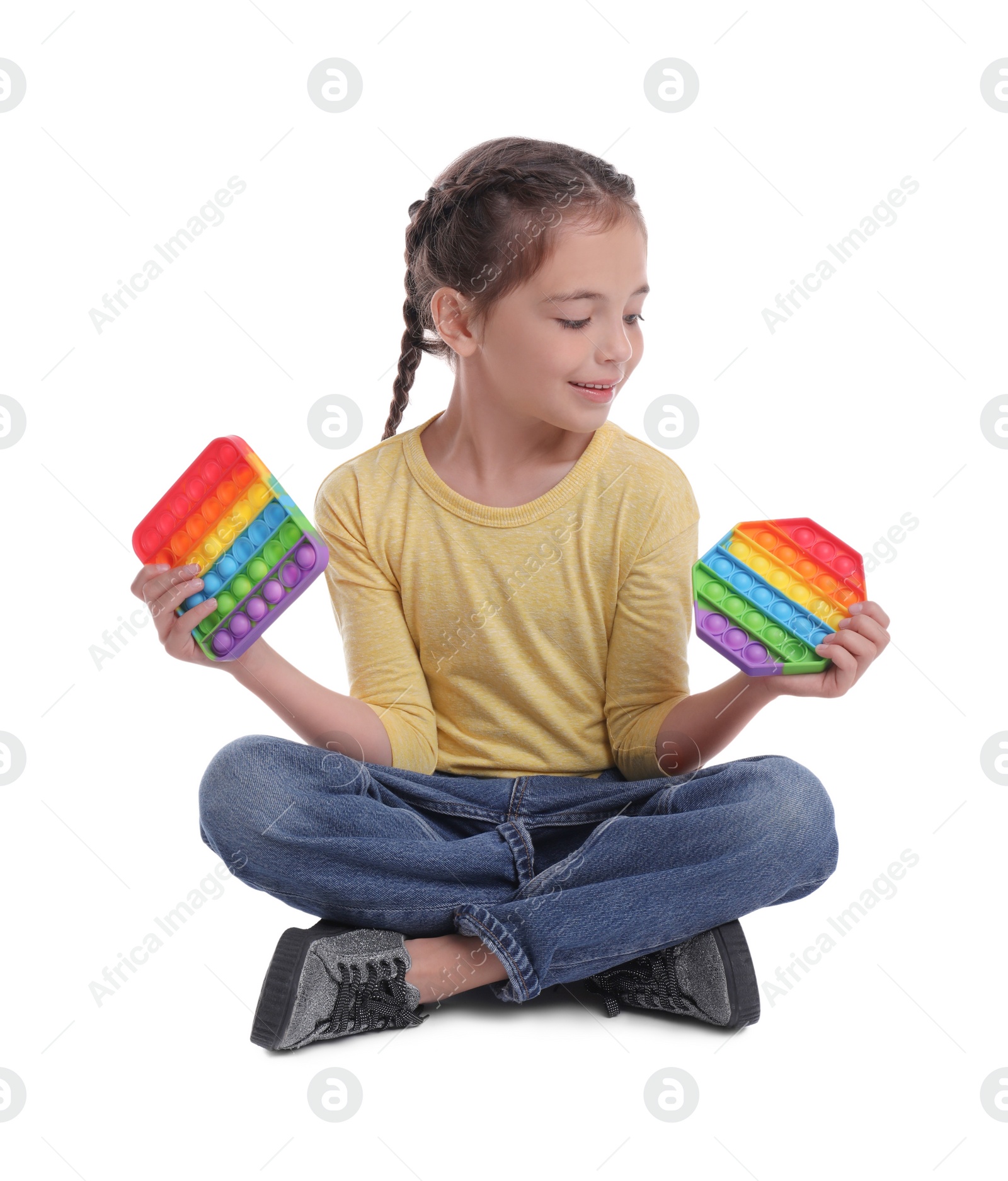 Photo of Little girl with pop it fidget toys on white background