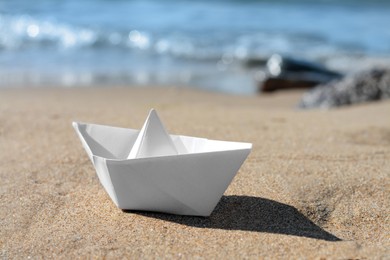 White paper boat near sea on sunny day, closeup