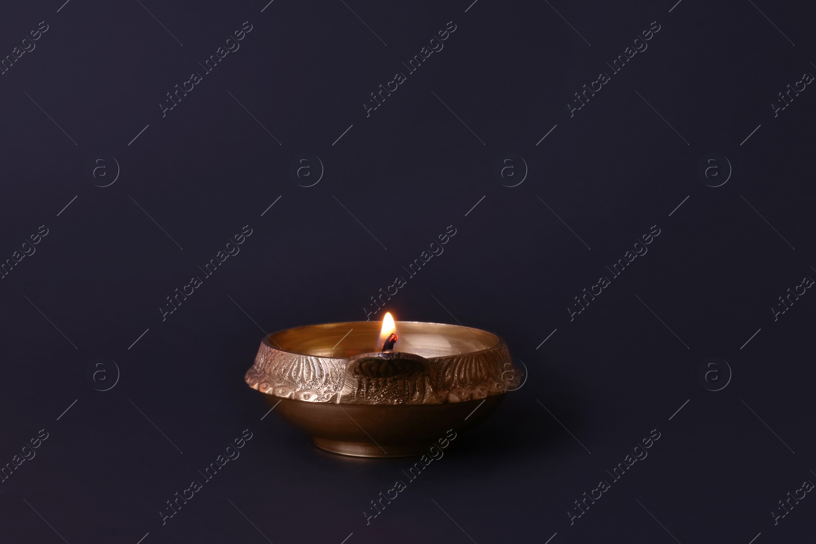 Photo of Lit diya lamp on black background. Diwali celebration