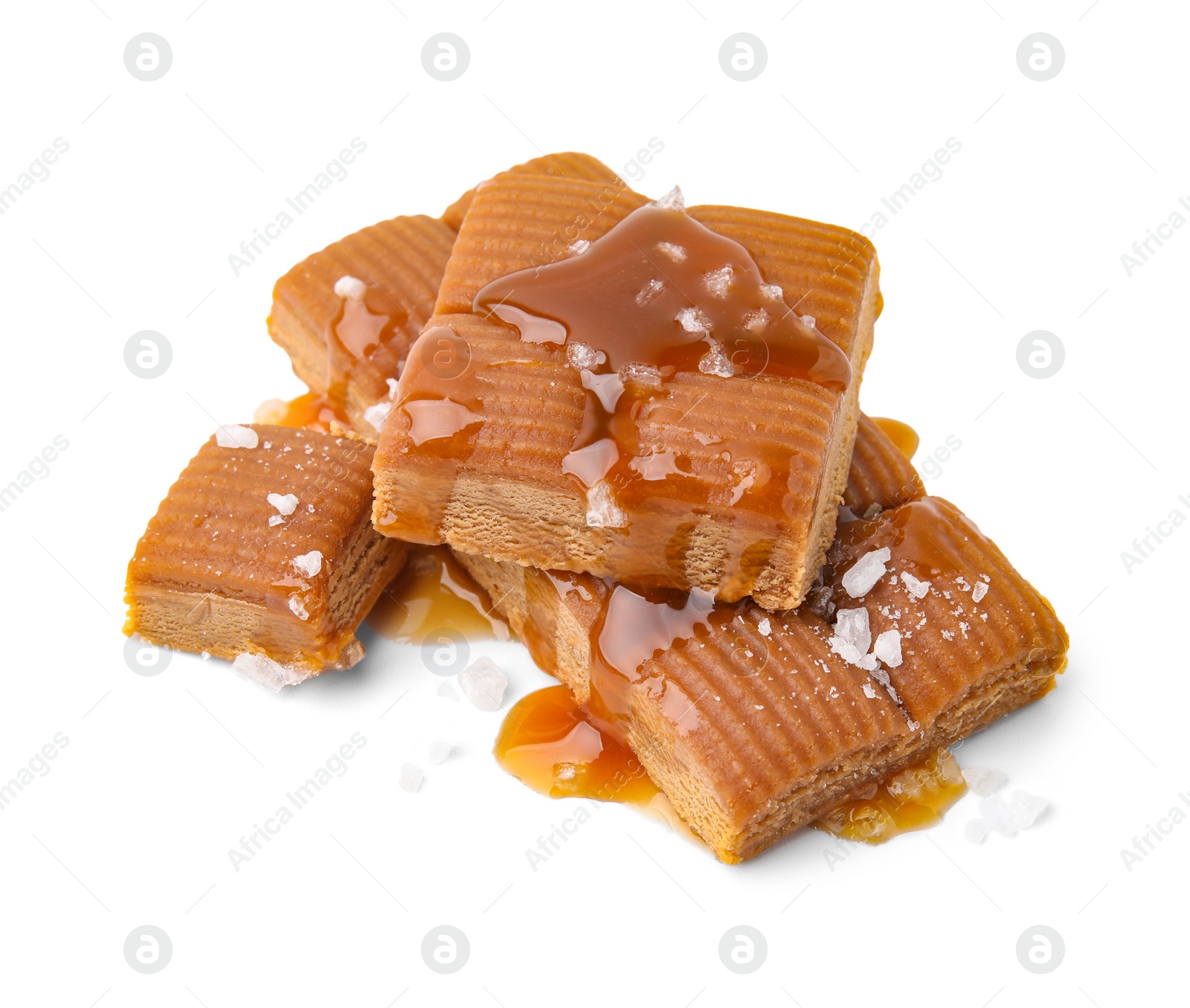 Photo of Yummy caramel candies and sea salt isolated on white