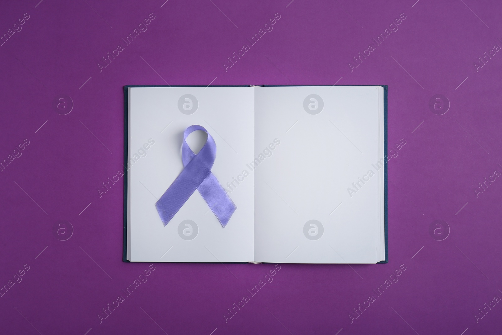 Photo of Purple awareness ribbon and open notebook on color background, top view with space for text