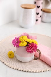 Beautiful bright flowers in cup on table