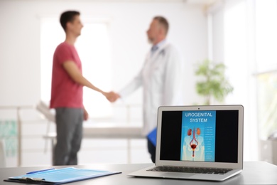 Laptop with picture of urogenital system and blurred people on background