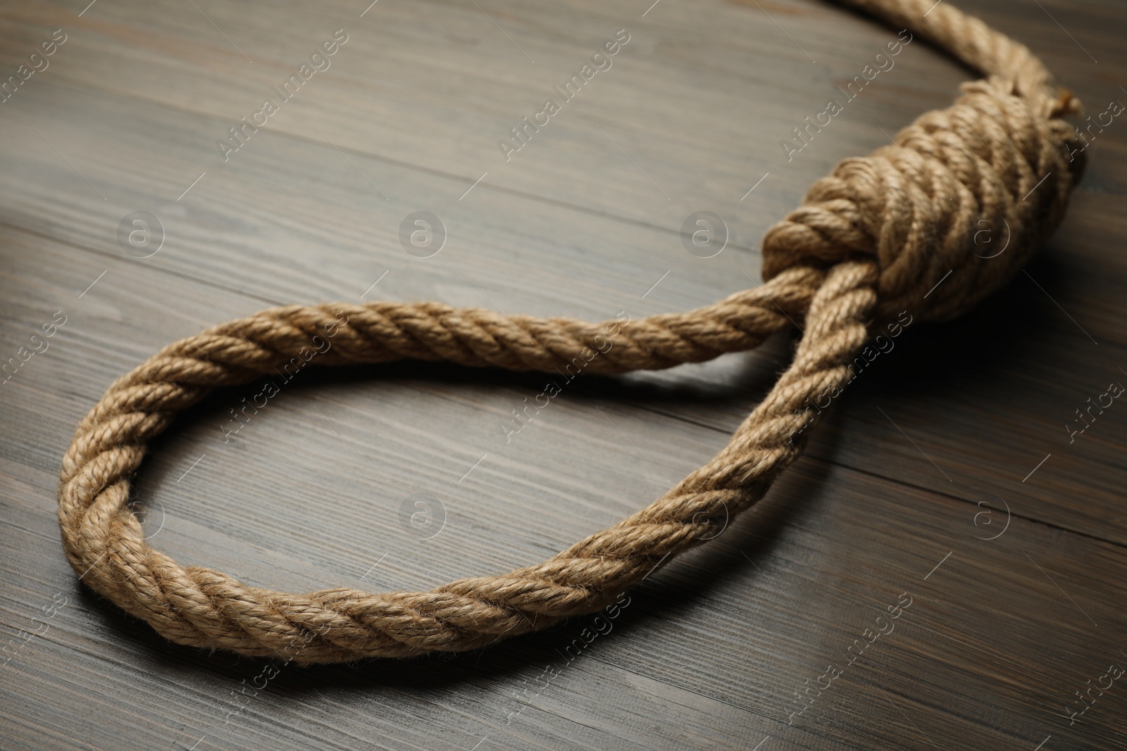 Photo of Rope noose on wooden table, closeup view