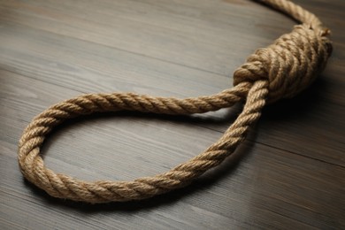 Rope noose on wooden table, closeup view