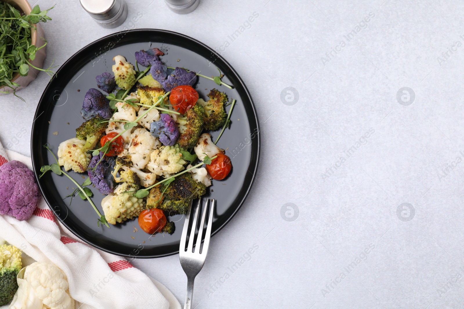 Photo of Delicious salad with cauliflower and tomato served on white table, flat lay. Space for text