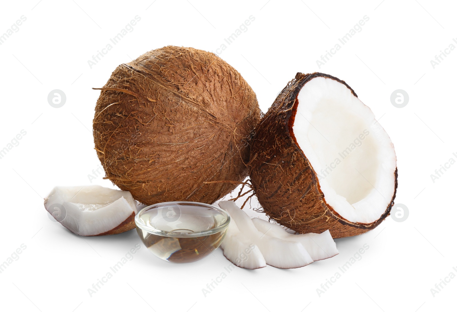 Photo of Ripe coconuts and bowl with natural organic oil on white background