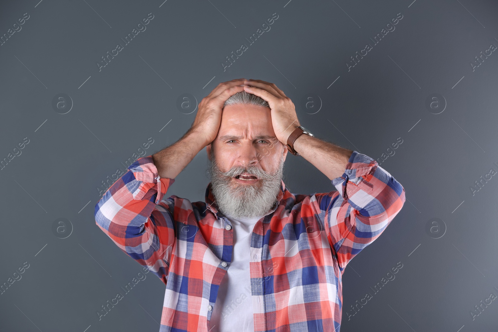 Photo of Handsome emotional mature man on color background