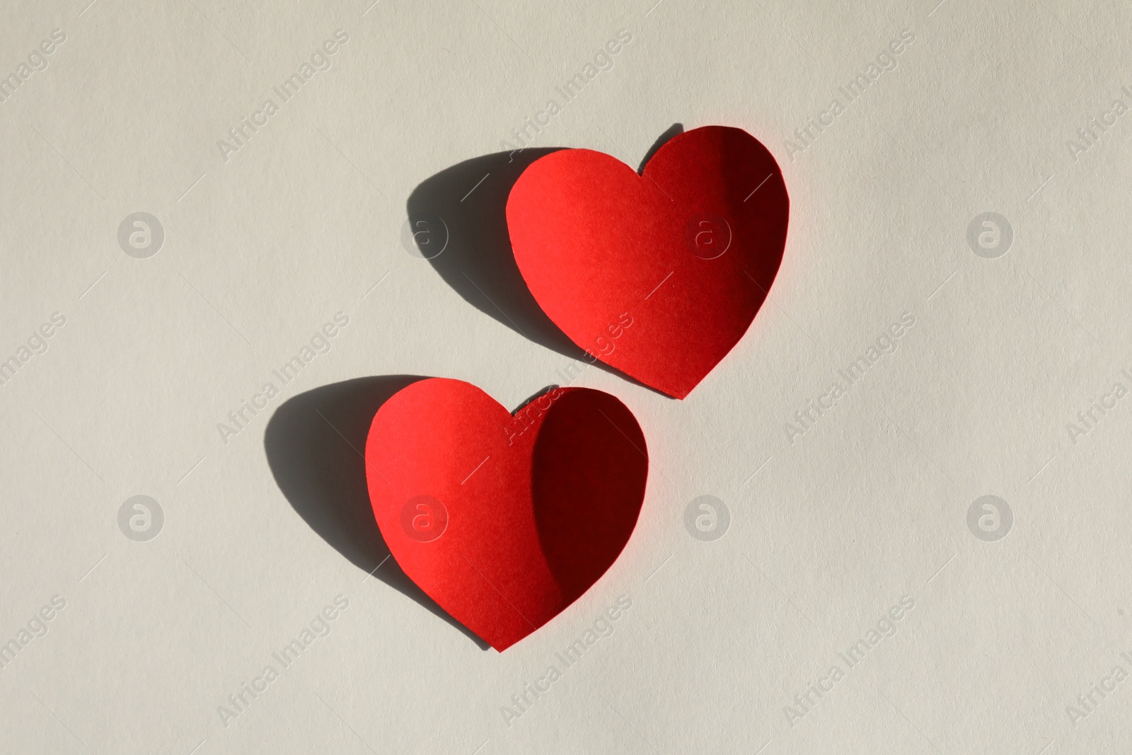 Photo of Paper hearts on light grey background, flat lay