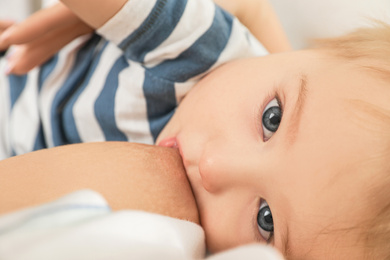 Woman breastfeeding her little baby, closeup view