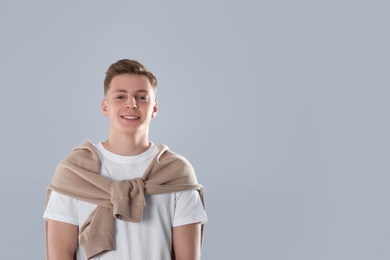 Photo of Portrait of teenage boy on light grey background. Space for text
